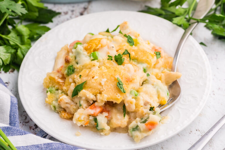TikTok Chicken Cobbler served on a white plate with creamy chicken, mixed vegetables, golden Cheddar Bay biscuit topping, and fresh parsley.