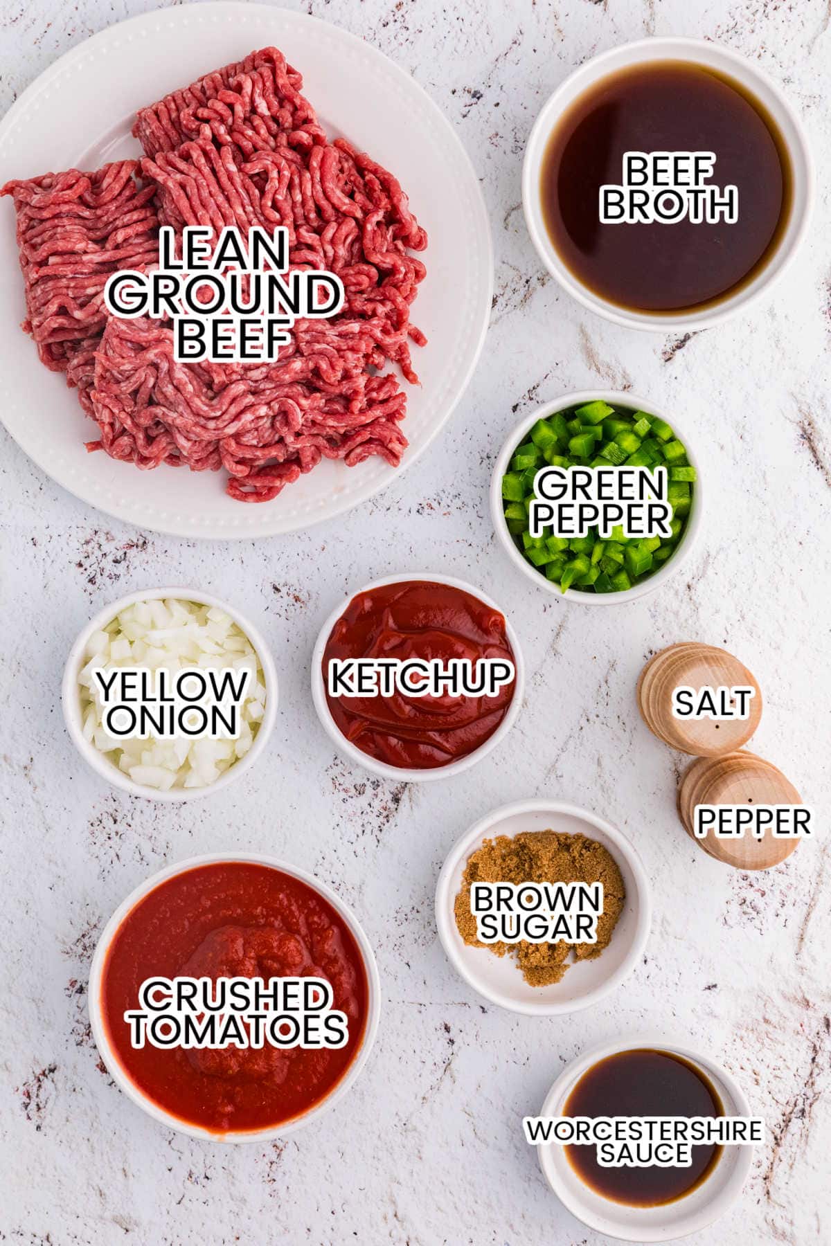 Overhead view of labeled ingredients: ground beef, broth, green pepper, onion, ketchup, crushed tomatoes, brown sugar, Worcestershire.